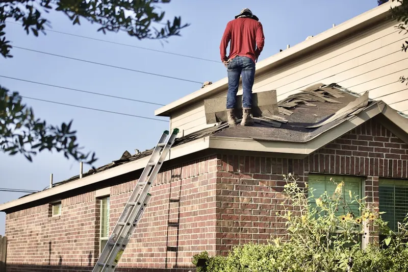 Professional roofer working on a residential roof in Salina
